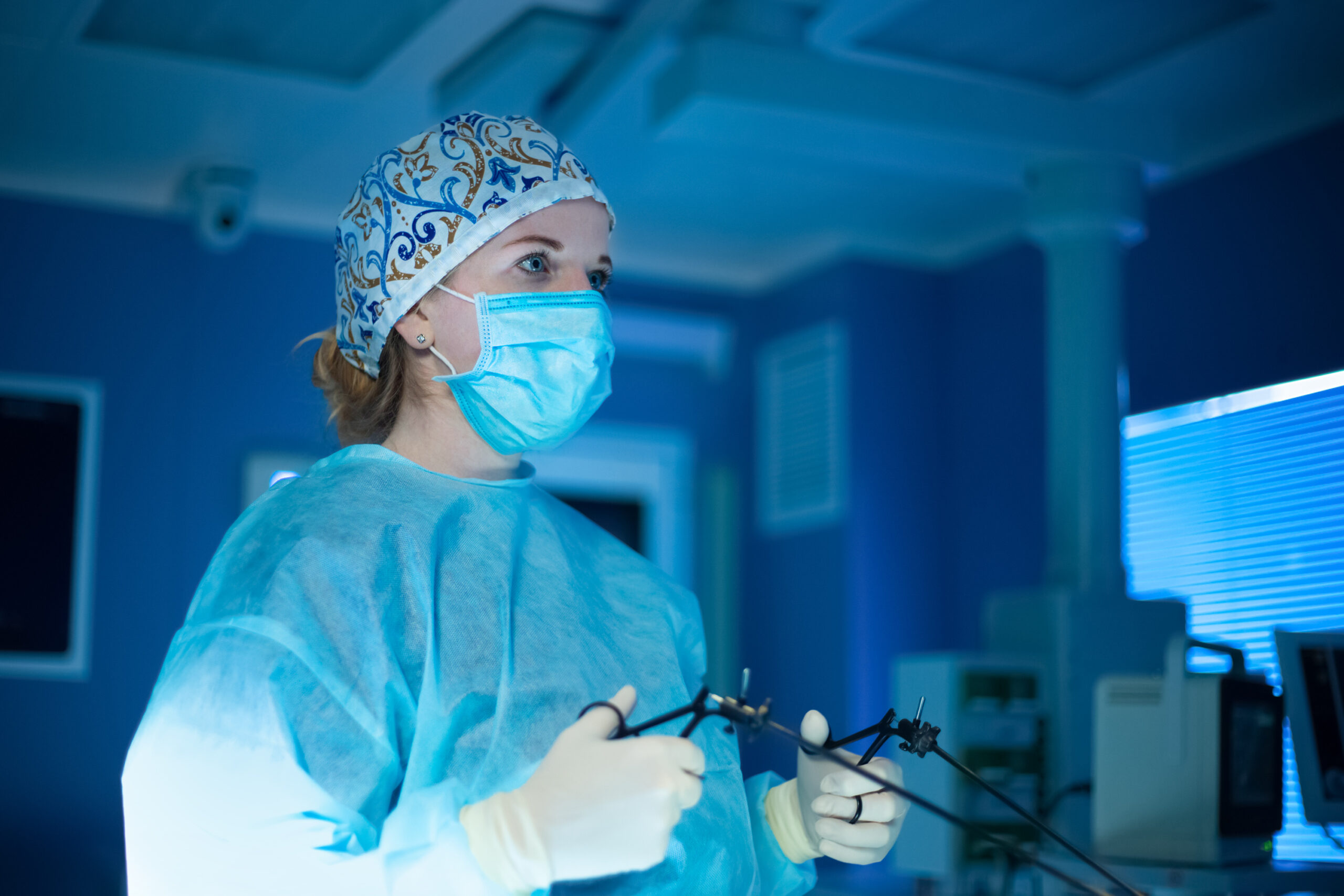 Эндоскопия сустава. Женщина хирург в операционной. Женщина хирург в квестах.
